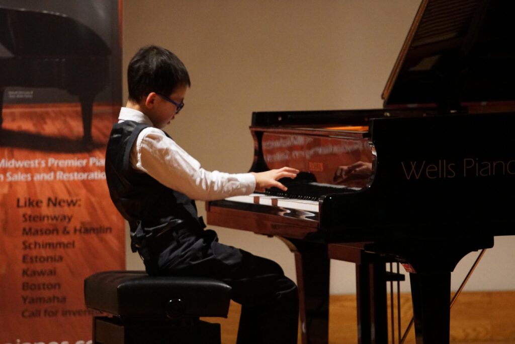 Kevin energetically playing piano as a young performer